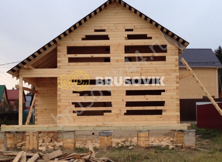 Деревянный дом с мансардой и крыльцом